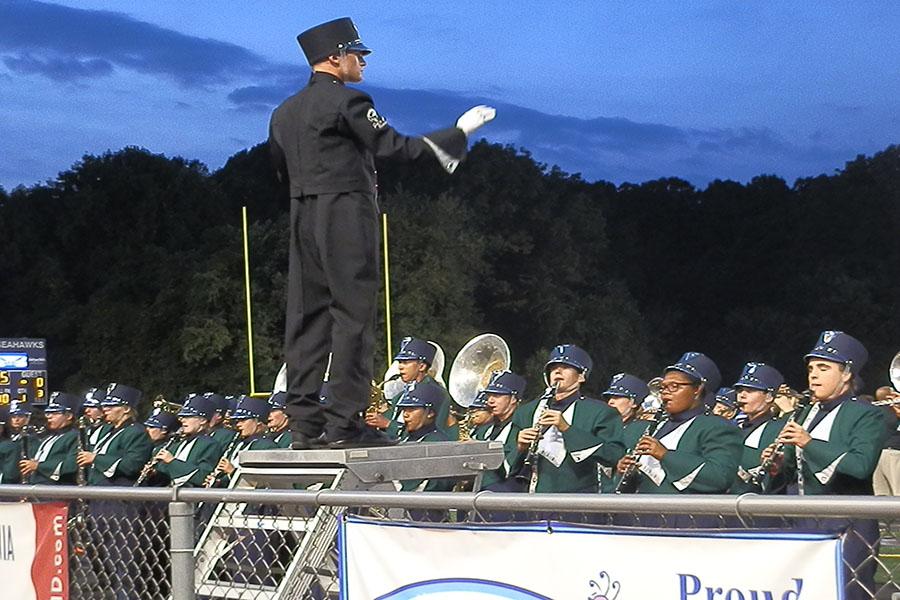 Senior drum major Jack Nicol conducts the marching bands performance at the football game against Herndon Sept. 20. Nicol and senior Ellen Lee lead the marching band this year. 