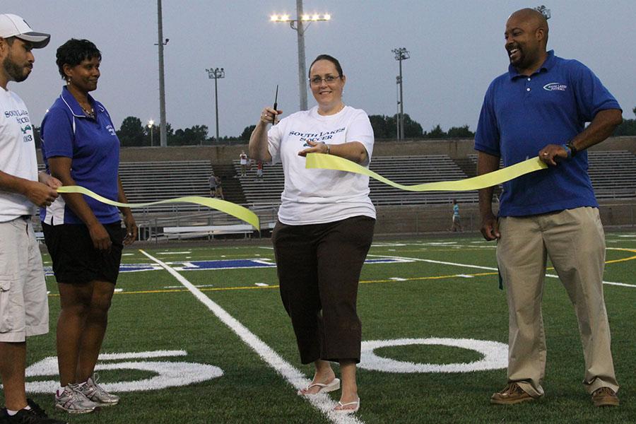 Principal+Kim+Retzer+cut+the+ribbon+for+the+first+game+played+on+the+new+turf+field.+