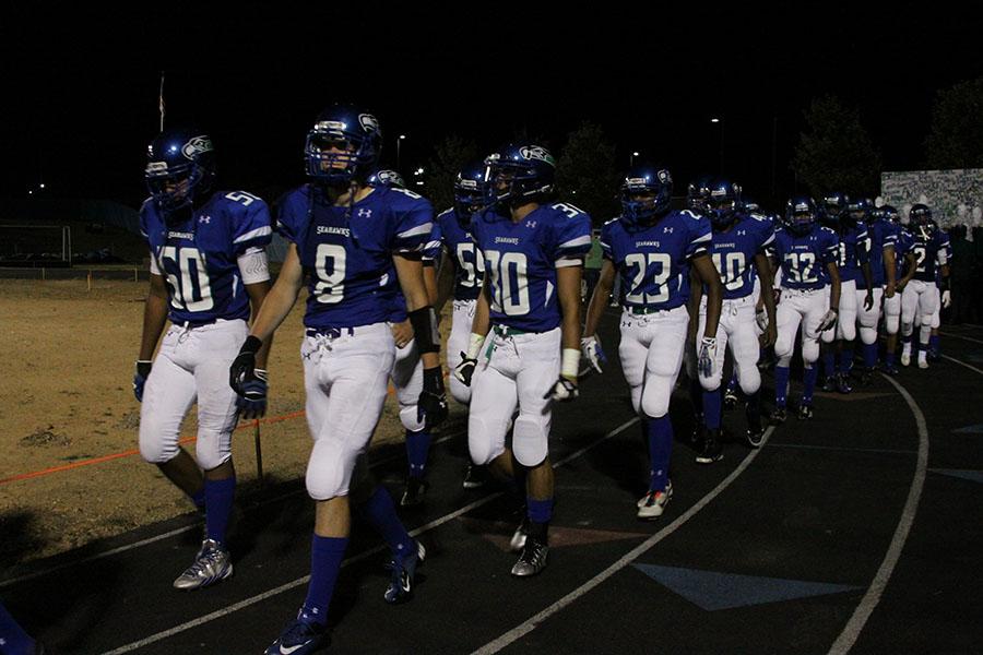 Varsity football walks onto the new turf field for the first time at the Westfield game Sept. 6.