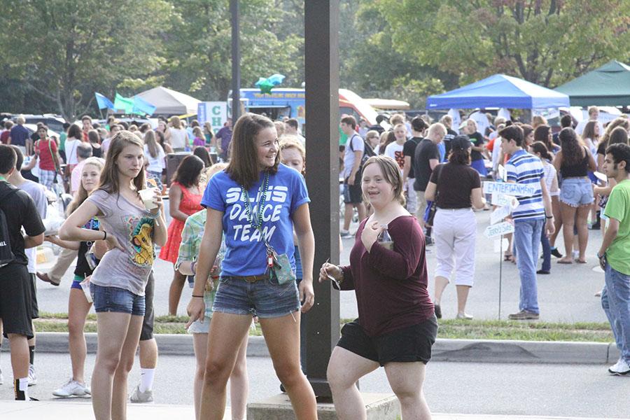 Seniors Erin Persil and Elizabeth Clark explore the various offerings at the block party. The block party was led by leadership class for the third year and it consisted of several dozen booths represeted by local businesses and school groups.