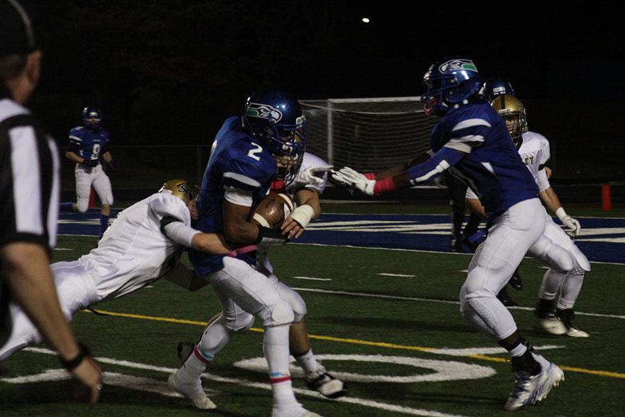 Senior Khayri Denny avoids a tackle as he runs the ball toward the end zone. 