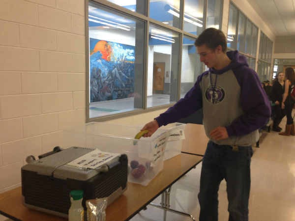 Freshman Ben Gryski donates to the new food rescue project spearheaded by seniors Miki Konishi and Scott Waters.