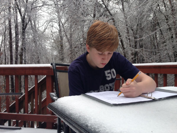 Sophomore Jarrod May takes advantage of the snow day and enjoys the outdoors while working on homework.