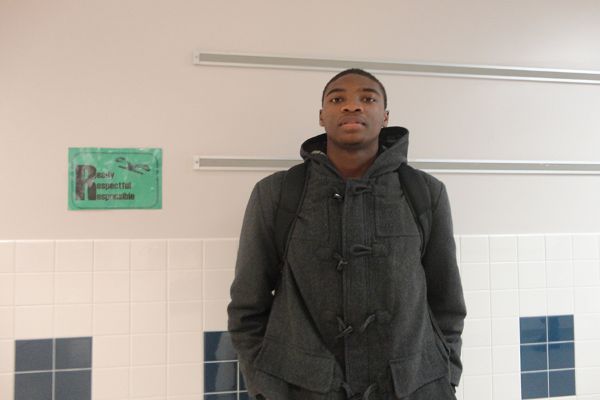 Junior combo guard Brandon Kamga poses in the hallway before a morning class. 