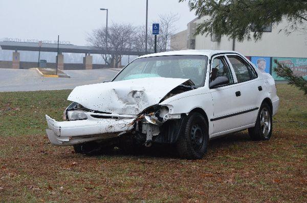 A wrecked car is displayed near the student parking lot as a reminder to students about the dangers of texting while driving. 