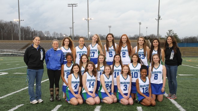 Girls+varsity+lacrosse+head+coach+Brittany+Stevenson+poses+with+her+team.+