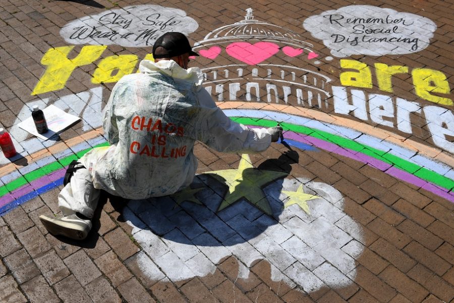 “Local artist Rajan Sedalia works on a mural at Eastern Market Metro Plaza on Tuesday.” - Via Katherine Frey/The Washington Post