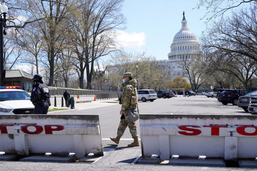 Troops stand guard after a car that crashed into a barrier on Capitol Hill in Washington, Friday, April 2, 2021. (AP Photo/Jacquelyn Martin)