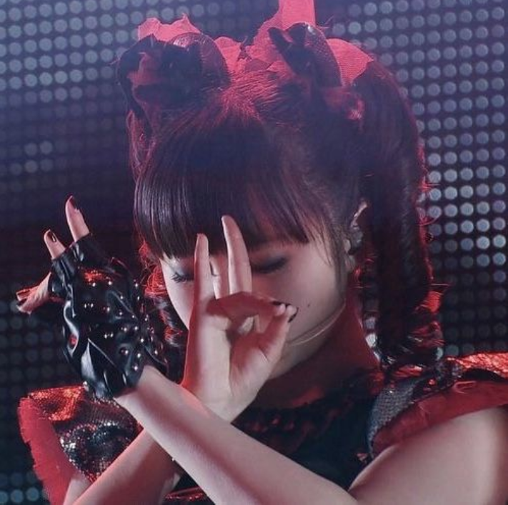 Moa Kikuchi (Moametal) haciendo el símbolo de la mano del Zorro mientras actúa.