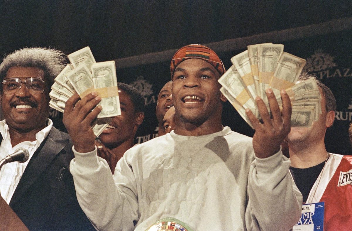 Después de derrotar a Carl Williams en Atlantic City el 21 de julio de 1989, Mike Tyson mostró un bono de $100,000 del promotor Don King, prometido por cada nocaut. (Foto AP/Bruce Boyajian)