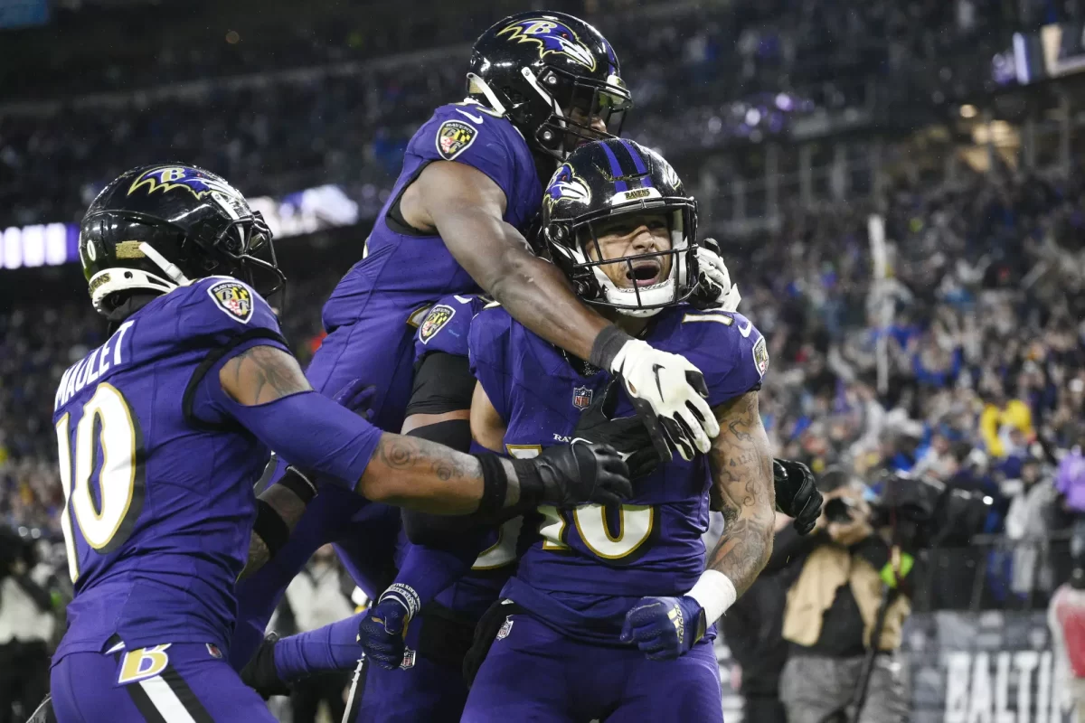 Baltimore Ravens punt returner Tylan Wallace, middle, celebrates with teammates after defeating the Rams on a 76-yard punt return in overtime. — Accredited to Sports Photographer Nick Wass from the Associated Press