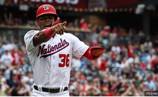 Nationals OF Stone Garrett points in the direction of the dugout. 
Image via/Forbes
