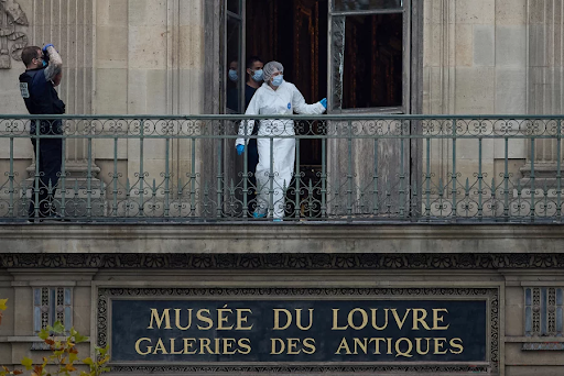 Image Via: Kiran Ridley/Getty Images
Forensic officers examining the cut window and balcony at the Louvre Museum on October 19th.